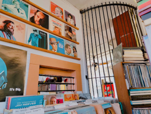 A cozy record store interior with vinyl albums displayed on walls and shelves, featuring a vintage aesthetic.