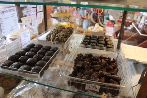 A display case filled with various types of chocolates and confections, including dark chocolate and nut treats.