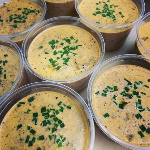 Containers of creamy soup topped with chopped green onions, arranged in a circular pattern.