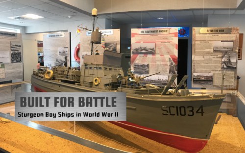 Model of a Sturgeon Boy ship from World War II displayed in a museum, with informative panels in the background.