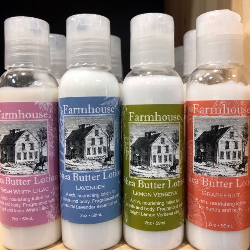 Four bottles of shea butter lotion in different scents: Fresh White Lilac, Lavender, Lemon Verbena, and Grapefruit.