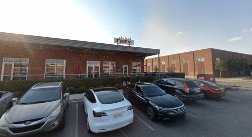 Exterior of a restaurant named "Frey" with outdoor seating and parked cars in front.