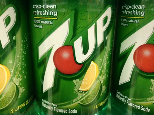 Three 2-liter bottles of 7UP soda, featuring a green label with a red circle and lemon-lime graphics.