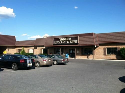 Exterior view of Yoder's Restaurant & Buffet, featuring a brick facade and parked cars in front.