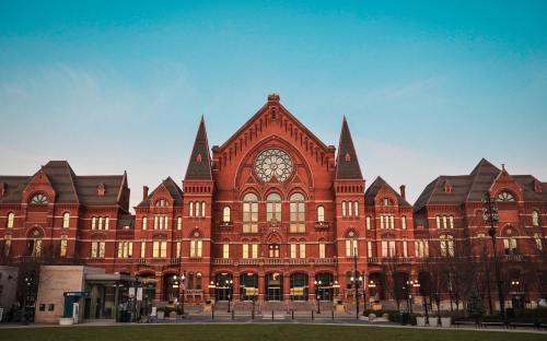 Historic red brick building with ornate architecture and a large circular window, set against a clear blue sky.