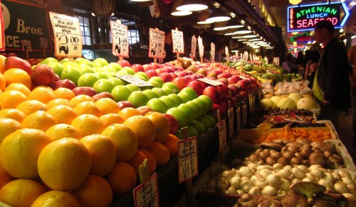 A vibrant market display featuring a variety of colorful fruits and vegetables with price tags.