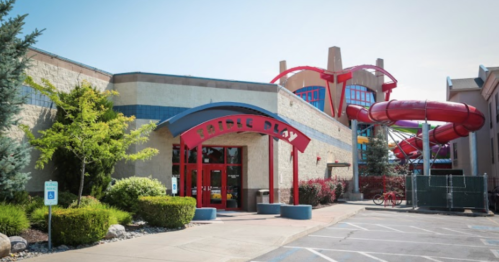 Exterior of a family entertainment center with colorful water slides and a welcoming entrance.