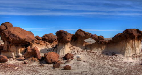 A desert landscape featuring unique rock formations and a clear blue sky.