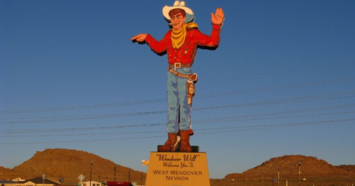 A large cowboy statue waves, welcoming visitors to West Wendover, Nevada, against a clear blue sky.