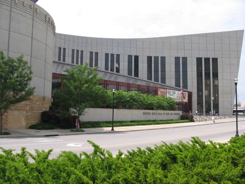 Exterior view of the Country Music Hall of Fame and Museum, featuring modern architecture and greenery in the foreground.