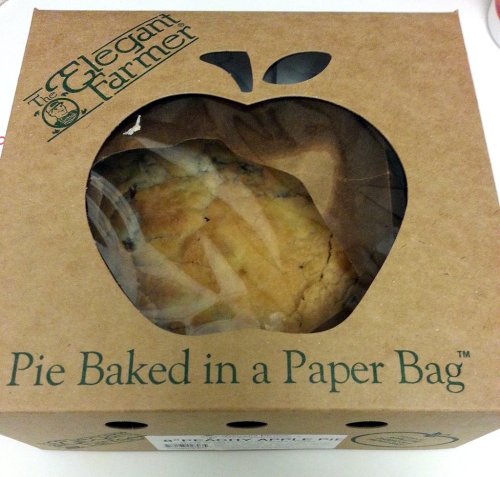 A brown box with a cut-out apple shape, labeled "Pie Baked in a Paper Bag," showing a glimpse of the pie inside.