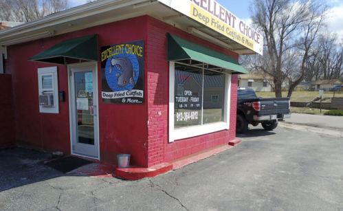 Exterior of "Excellent Choice" restaurant, featuring a sign for deep-fried catfish, with a pickup truck parked nearby.