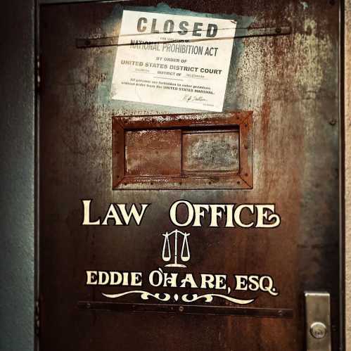 A closed law office door with a sign about the National Prohibition Act and the name Eddie O'Hare, Esq.