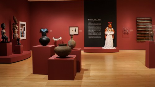 Art gallery featuring various artifacts and sculptures, with a prominent display of a figure in traditional attire.