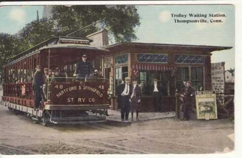 Historic trolley waiting station in Thompsonville, Connecticut, with a trolley and passengers in vintage attire.