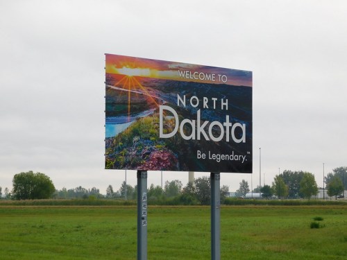Welcome sign for North Dakota featuring a scenic landscape and the slogan "Be Legendary."