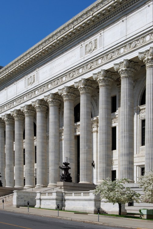 A grand building with tall columns and intricate architectural details, labeled "State Education Building."