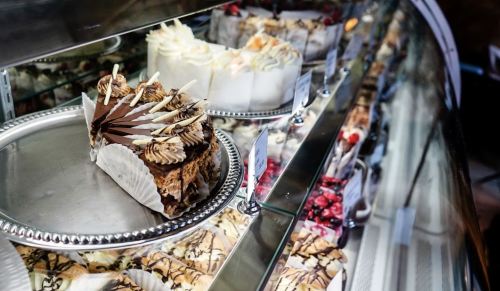 A display case filled with various cakes and desserts, including a chocolate cake with decorative toppings.