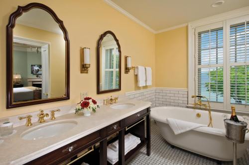 Elegant bathroom featuring dual sinks, a freestanding tub, and large windows with natural light.