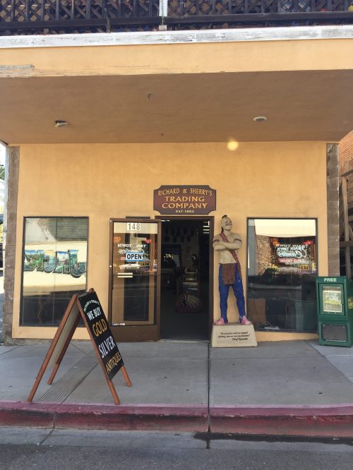 Entrance of Richard & Sherry's Trading Company, featuring a signboard and a statue outside the door.