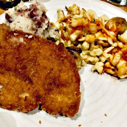 A plate featuring crispy fried chicken, creamy mashed potatoes, and a colorful vegetable medley.