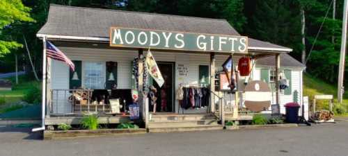 A quaint gift shop named "Moody's Gifts" with a porch displaying various items and an American flag.