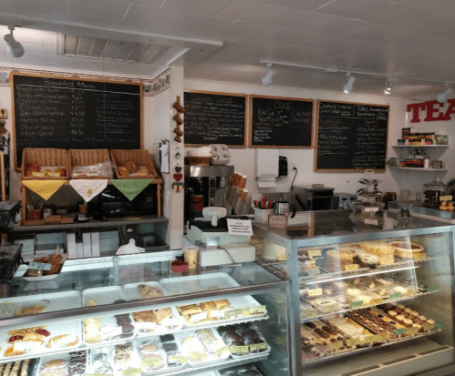 A cozy bakery display with pastries, a chalkboard menu, and a glass case filled with desserts.