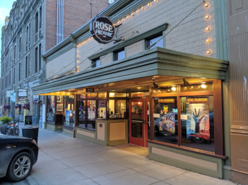 The Rose Theatre entrance features marquee lights and movie posters, set in a historic building on a city street.