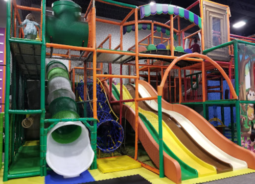 Colorful indoor playground with slides, climbing structures, and tunnels for children to play and explore.