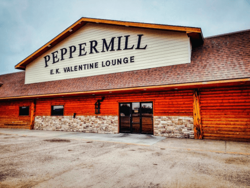 Exterior of the Peppermill E.K. Valentine Lounge, featuring a wooden facade and a large sign.