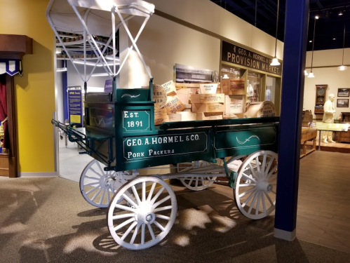 A vintage delivery wagon from Geo. A. Hormel & Co., established in 1891, filled with wooden crates.