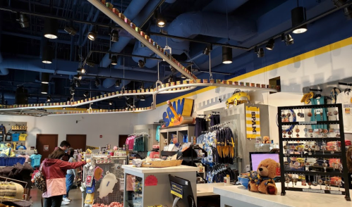 A colorful retail store interior with merchandise displays, a checkout area, and customers browsing.