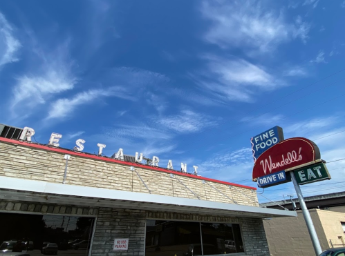 A retro restaurant exterior with a sign reading "Wendell's Drive-In" and a blue sky with scattered clouds.