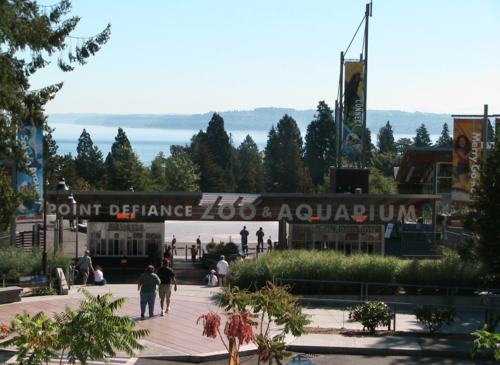 Entrance to Point Defiance Zoo & Aquarium, surrounded by trees and overlooking a scenic view of the water.