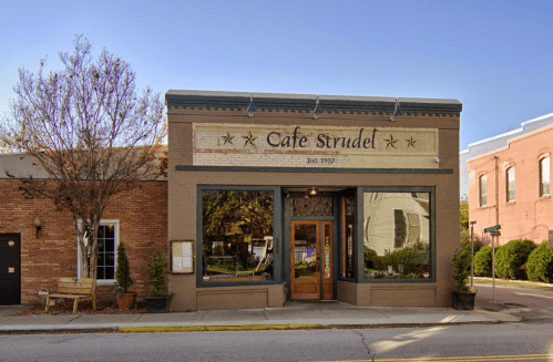 A charming café named "Cafe Strudel," featuring a vintage facade and large windows, established in 1992.