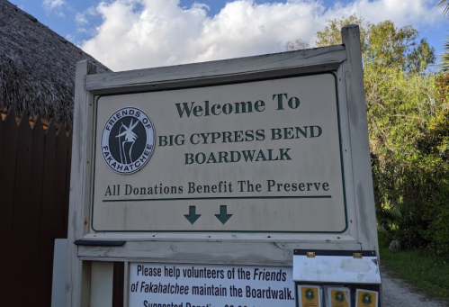 Sign welcoming visitors to Big Cypress Bend Boardwalk, noting donations benefit the preserve and volunteer opportunities.