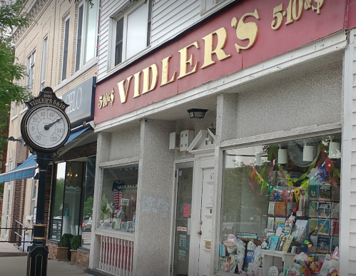 Storefront of Vidler's 5-10-25 cent store with a vintage clock nearby, showcasing colorful merchandise in the window.