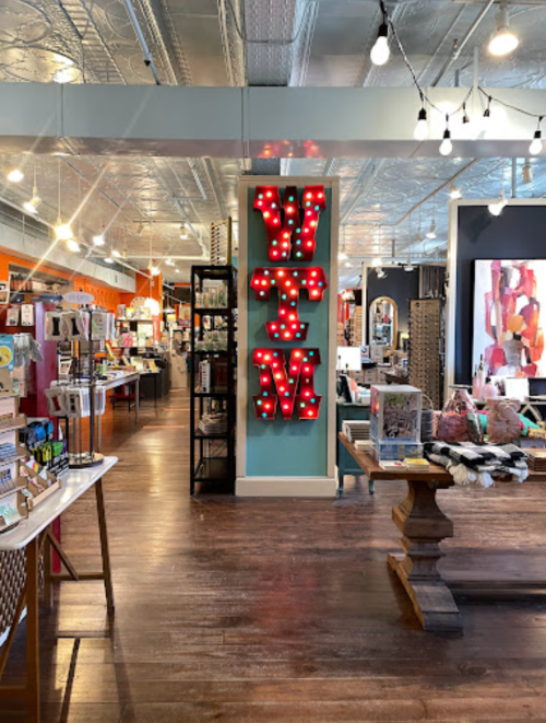 A brightly lit store interior featuring colorful displays, a "WTM" sign, and various home decor items.