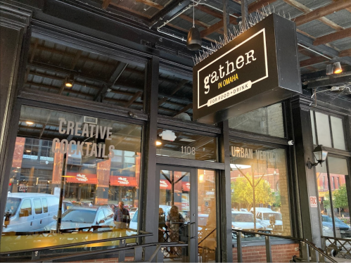 Exterior of Gather restaurant in Omaha, featuring a sign and large windows showcasing the urban setting.