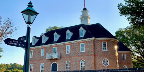 Historic brick building with a cupola, surrounded by trees, and a street sign for Blair and Duke of Gloucester.
