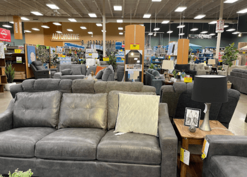 A spacious furniture store showcasing various sofas and seating arrangements, with a focus on a gray couch in the foreground.