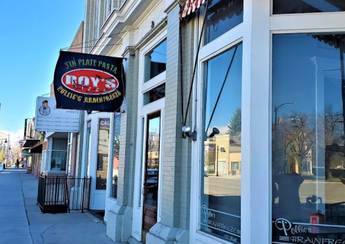 Exterior view of a restaurant with a sign reading "Roy's" and "Pollie's Brainerd" on a sunny day.