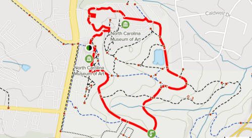 Map showing a red trail route around the North Carolina Museum of Art, with nearby roads and paths indicated.