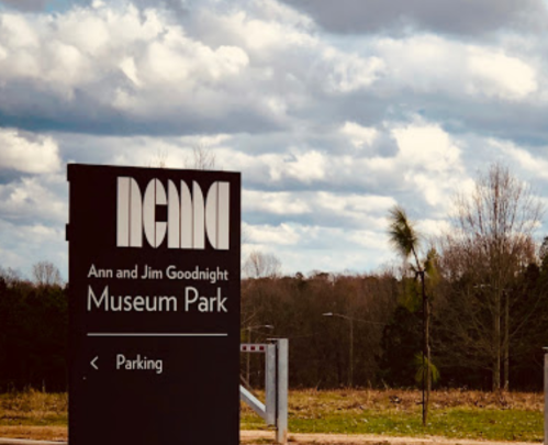 Sign for Ann and Jim Goodnight Museum Park with cloudy sky in the background.