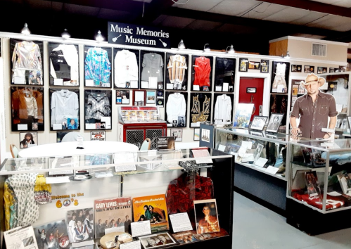 Interior of the Music Memories Museum, featuring memorabilia, clothing, and photos of various artists on display.