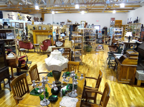 A spacious antique store filled with wooden furniture, vintage decor, and various collectibles on display.