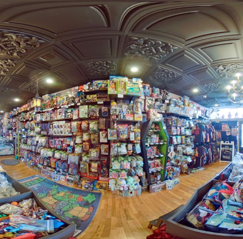 A vibrant toy store filled with shelves of colorful toys, games, and collectibles under an ornate ceiling.