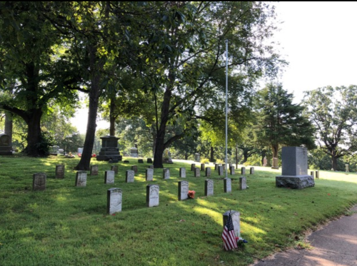 A peaceful cemetery with gravestones, trees, and an American flag, bathed in soft morning light.