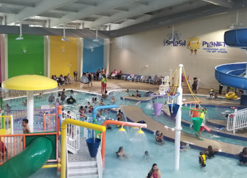Indoor water park with slides, pools, and children playing in a vibrant, colorful environment.