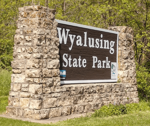 Sign for Wyalusing State Park, featuring stone pillars and greenery in the background.